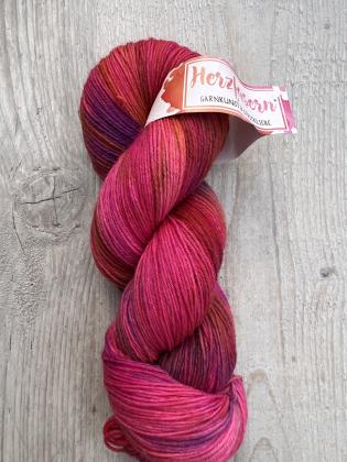 Dieses Garn wurde moeglichst farbecht fotografiert. Je nach Bildschirm koennen die Farben abweichen. Farbtoene in Worten beschrieben: kraeftiges Pink, Beerentoene, helle Rosaaufhellungen und leuchtende Highlights.  ALT-Texte fuer Screenreader: 	1.	Ein Str